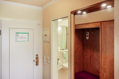 汉诺威Hotel Münkel的浴室设有木门和镜子