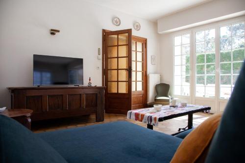 拉波勒Villa Topaze La Baule les Pins的客厅配有电视和桌子