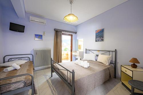 鲁维斯Iliahtida Apartments的一间卧室设有两张床、一台电视和一扇窗户。