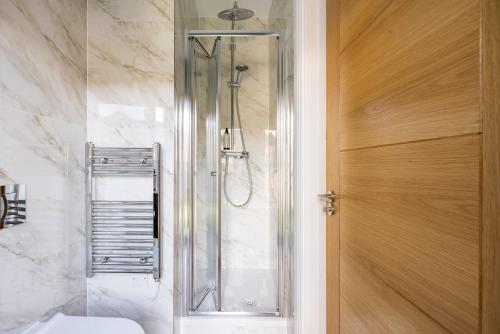 斯坦斯Staines Riverside by Charles Hope的带淋浴的浴室和玻璃门