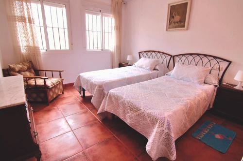 丰特-德彼德拉Casa Gracia Málaga Corazón de Andalucía的一间卧室配有两张床和椅子