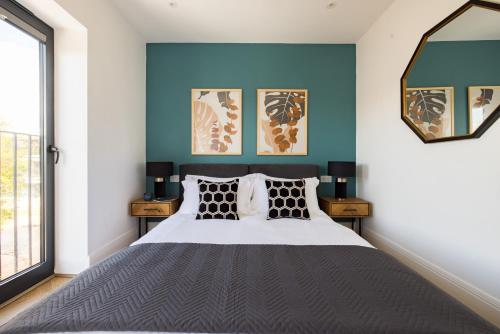 斯坦斯Staines Riverside by Charles Hope的一间卧室配有一张带蓝色墙壁的大床