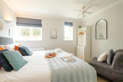 Aldringham1 Hazelwood, Aldeburgh的卧室配有一张白色的大床和一张沙发。