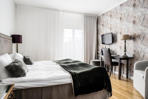 Ösmo科润达高尔夫及会议酒店的一间卧室配有一张大床、一张桌子和一张桌子