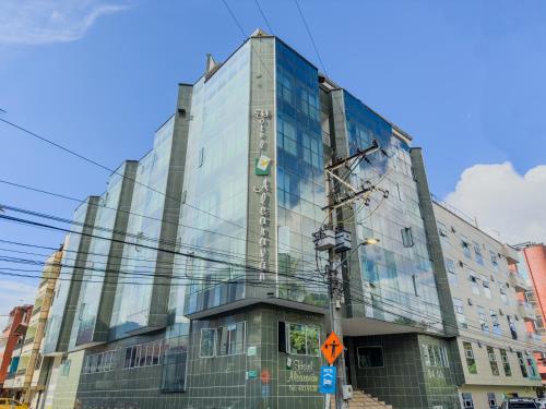 麦德林Hotel Alcaravan Medellín的城市街道上的玻璃建筑