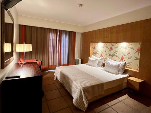 丰沙尔图里斯阿特兰蒂达酒店的酒店客房设有一张大床和一盏灯。