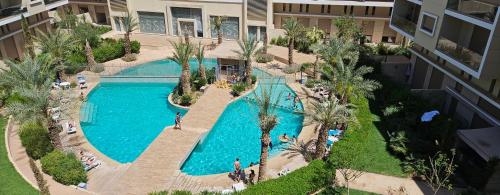 马拉喀什Marrakesh Pearl Gardens Amazing 2 Bedrooms apartment的享有度假村游泳池的顶部景致