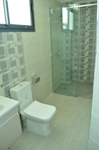 非斯حي الأدارسة فاس的一间带卫生间和玻璃淋浴间的浴室