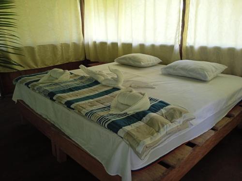 NautaAmazon Jungle Reps的一张带毛巾和枕头的床