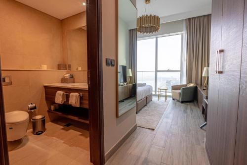 迪拜Avani Plus Palm View Dubai Suites的酒店客房设有带卫生间的浴室和电视。