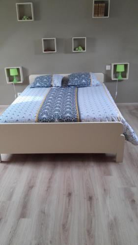 BrézéChambre的卧室铺有木地板,配有一张白色的床。