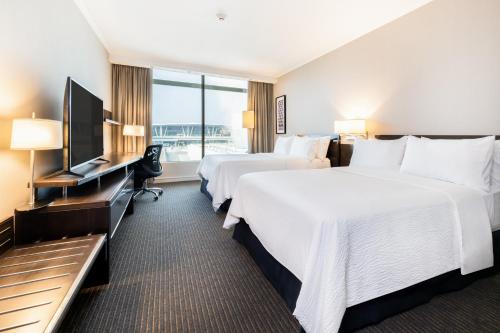 圣地亚哥圣地亚哥假日酒店 - 机场航站楼的酒店客房设有两张床和一台平面电视。