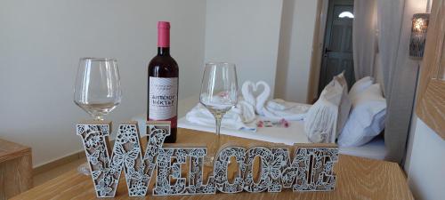 艾拉方索斯Selinopetra Rooms的桌子上放有一瓶葡萄酒和两杯酒