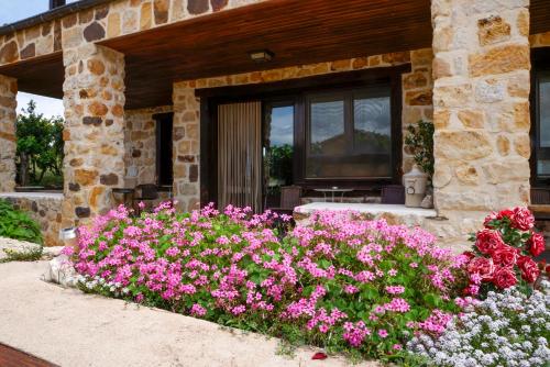 ValdelinaresHotel Valdelinares (Soria)的一座花园,在一座建筑前方种有粉红色花卉