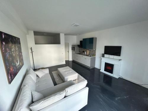 奥尔登堡Modern eingerichtetes Apartment zum entspannen und wohlfühlen的客厅配有白色沙发和壁炉