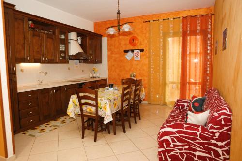 潘泰莱里亚LE CASE DI CICCIO - Casa Girasole的厨房以及带桌子和沙发的用餐室。
