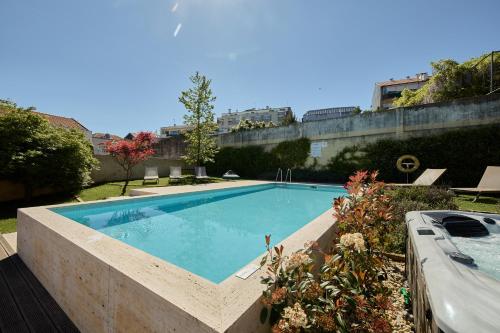 波尔图Aparthotel Oporto Anselmo的一座种植了植物的院子内的大型游泳池