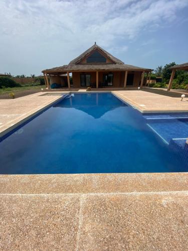 NianingMagnifica villa con giardino e piscina的房子前面的蓝色游泳池