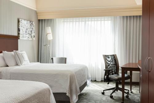 哥伦比亚哥伦比亚万怡酒店的酒店客房设有两张床、一张书桌和一个窗户。