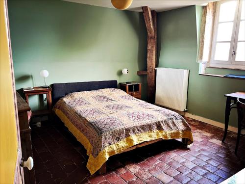 阿瓦隆Maison Beurdelaine的卧室设有一张位于绿色墙壁上的床铺