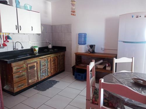 雅瓜鲁纳Apartamento a Beira Mar的厨房配有水槽、冰箱和桌子