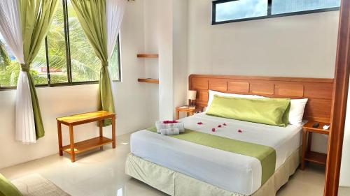 阿约拉港Hostal Sueños Silvestres的一间卧室配有一张带绿色和白色床单的床