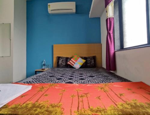 纳西克Ambient Homestay by NESTEASY的一间卧室设有一张蓝色墙壁的大床