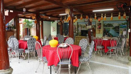 Ban Hin LomHomestay Minh Ngọc的餐厅设有红色的桌椅,上面有黄色的花瓶