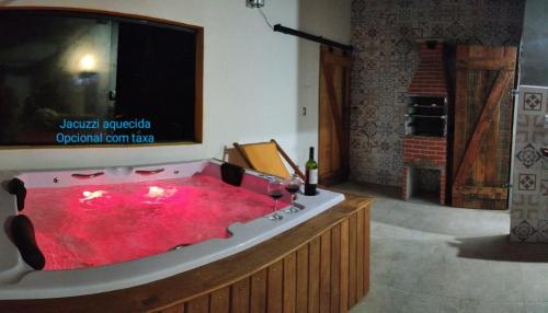 卡拉瓜塔图巴casa condomínio próximo à praia的带电视的客房内的红色浴缸