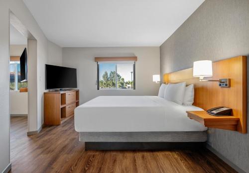 钱德勒钱德勒凤凰广场凯悦酒店 - 时尚中心的一间卧室配有一张大床和电视