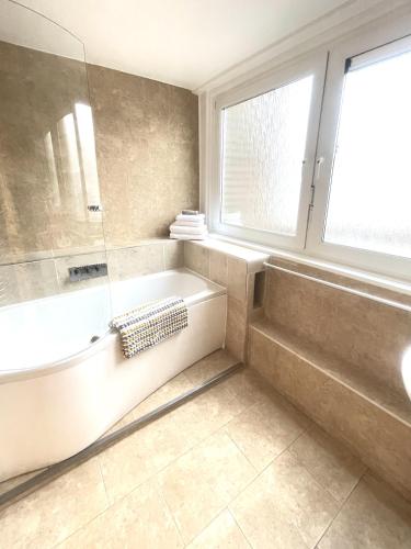 伦敦Newly Renovated 2BR Apartment in the heart of London的带浴缸、淋浴和盥洗盆的浴室