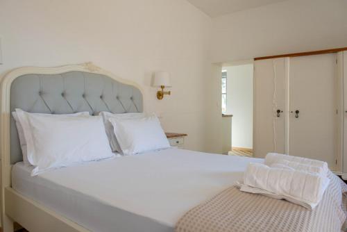 伊兹拉Blue Coral Hydra的卧室配有白色大床和白色枕头