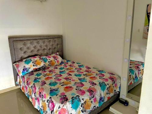 巴耶杜帕尔casa- festival vallenato的卧室内的一张带花卉棉被的床