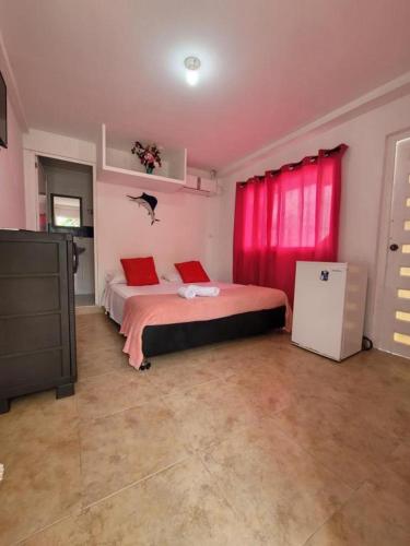 BuenavistaMangrove Bay Hotel的一间卧室配有一张带红色窗帘的大床