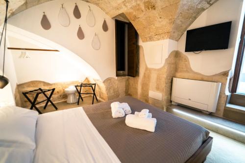莫诺波利Palazzo Fiscaiolo的一间卧室配有一张床,上面有两条毛巾