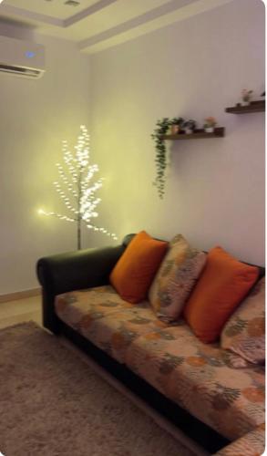 斯法克斯Dar Mim的客厅配有沙发,墙上挂着一棵树