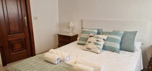 拉科萨Apartamento Raxobrisamar的一间卧室配有一张带蓝色和白色枕头的床