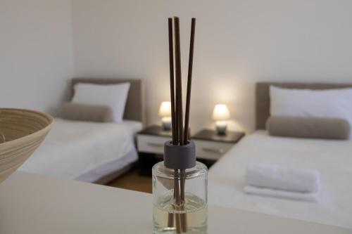萨拉热窝Apartment Nanami的一张带两张床铺的桌子上用棍子打的花瓶