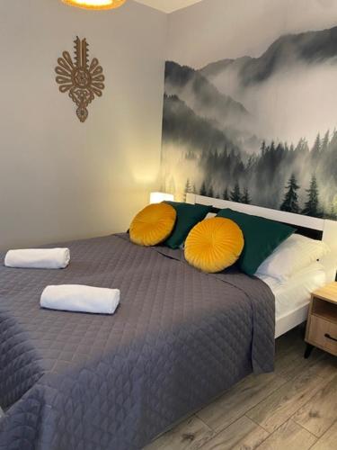 扎科帕内Apartament pod Smrekiem的一间卧室配有一张带两个黄色枕头的床