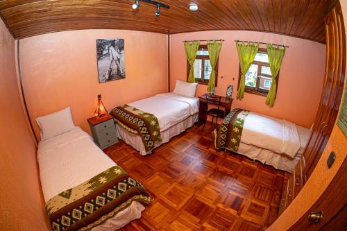 巴尼奥斯La Casa del Molino Blanco B&B的小房间设有两张床和一张桌子