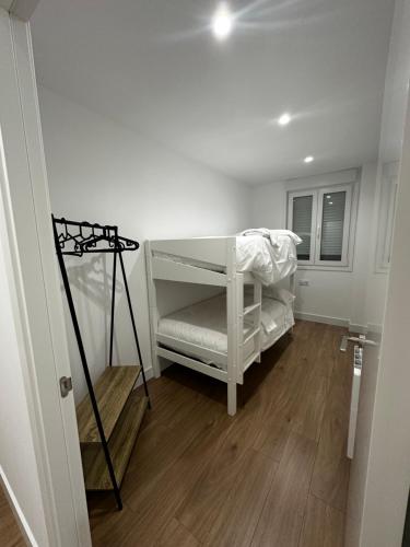 雷东德拉O LAR DE DON BASILIO的一间铺有木地板的客房内配有白色婴儿床的客房
