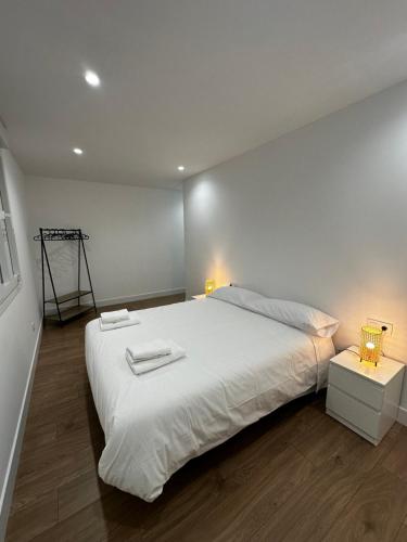 雷东德拉O LAR DE DON BASILIO的卧室配有一张白色大床和两盏灯。