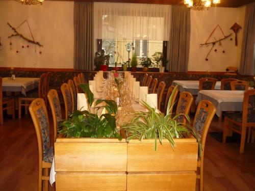克查赫Gasthof-Fleischerei Engl的一间用餐室,配有长桌子和植物