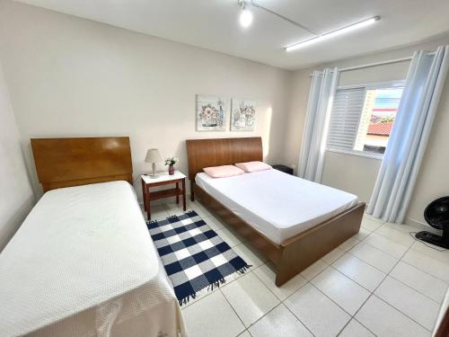 皮拉西卡巴Casa Ampla - Ótima Localização的一间卧室设有两张床和窗户。