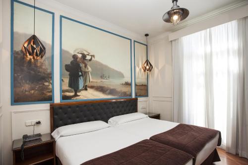 瓦伦西亚Olympia Consul del Mar的卧室配有一张床,墙上挂有绘画作品