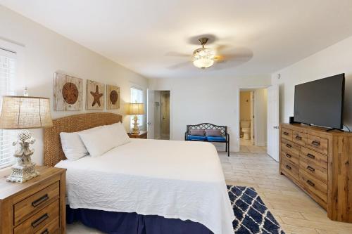 奥兰治比奇Bayou Boogie的卧室配有白色的床和平面电视。