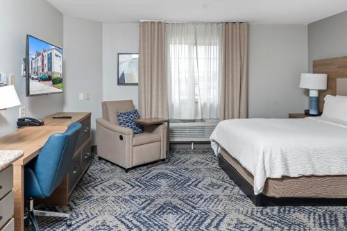尼德兰Candlewood Suites Port Arthur/Nederland, an IHG Hotel的酒店客房配有一张床、一张桌子和一把椅子。