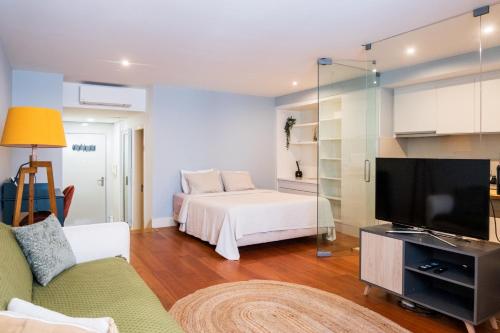里斯本Apartment in Santos的一间带床和电视的客厅
