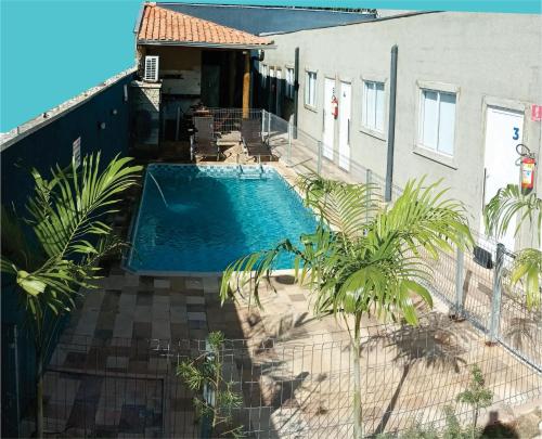 奥林匹亚OLÍMPIA APARTS Kitnet com cozinha e banheiro privativo PISCINA AQUECIDA的一座游泳池,位于一座建筑旁的院子内