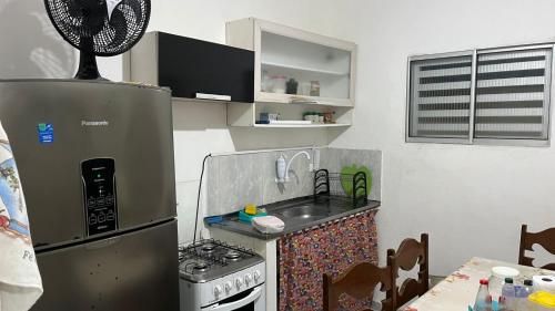 卡博迪圣阿戈斯蒂尼奥Condomínio Enseada dos Corais apto completo的一间带水槽和冰箱的小厨房
